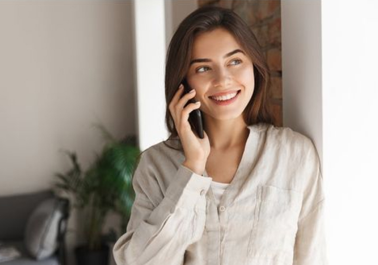 Image of a woman in business attire, looking at her phone.